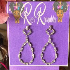 Silver costume rhinestone teardrop earrings 1.5 in long .5 in wide.